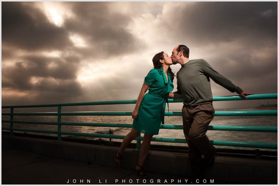 engagement in Manhattan Beach pier under Dramatic lighting